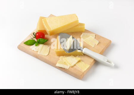 parmesan cheese and cheese knife on wooden cutting board Stock Photo