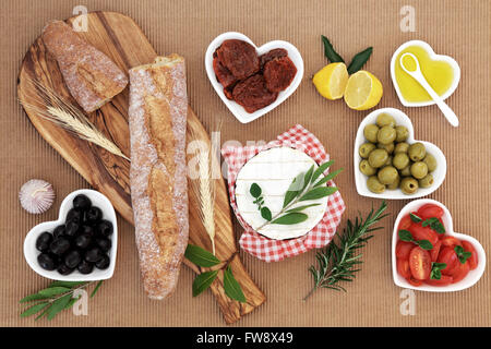 Picnic food with french baguette loaf on an olive wood board. Stock Photo