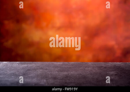 Empty concrete table and abstract batik orange- red background ready for photomontage. Empty space for your products and info. Stock Photo