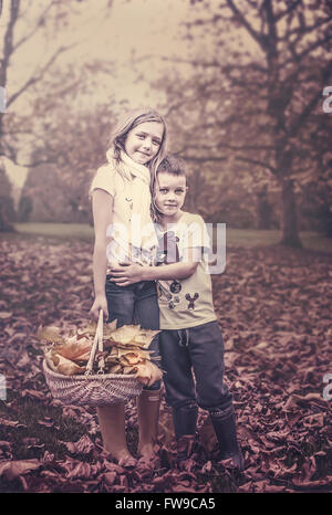 two kids in autumn park holding each other Stock Photo