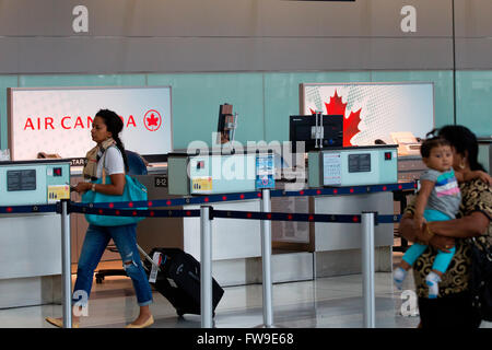 A woman walks by an empty Air Canada check in counter at Terminal 1 at Pearson International airport in Toronto, Ontario. Stock Photo