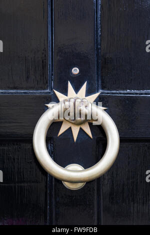 Hand door knocker on a black wooden door. Stock Photo