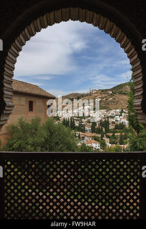 View of white houses of Granda Andalucia through a arched window from alhambra palace Stock Photo