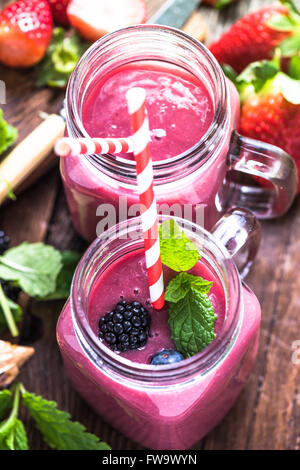 Well being and weight loss concept, berry smoothie.On wooden table with ingredients, from above. Stock Photo