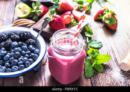 Well being and weight loss concept, berry smoothie.On wooden table with ingredients, from above. Stock Photo