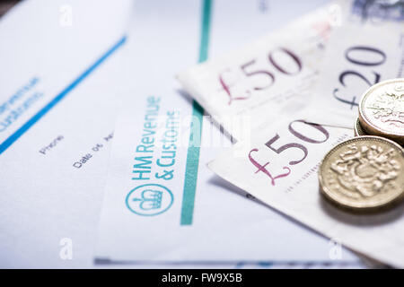 Paying taxes in Uk, British sterling notes and pound coins Stock Photo