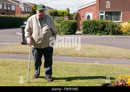 Elderly man walking with a stick Stock Photo