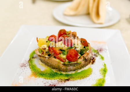 Fish baked with potatoes and tomatoes Stock Photo