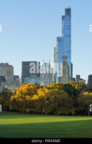 Autumn sunrise in Sheep Meadow, Central Park with view on Midtown Manhattan skyscrapers with One57 and Essex House. New York Stock Photo
