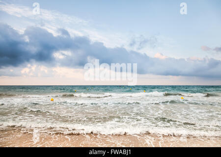 Surf on sandy Mediterranean beach at early morning Stock Photo