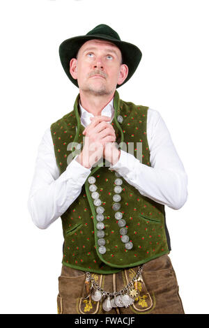 portrait of bavarian man wearing traditional bavarian clothes praying and looking up Stock Photo
