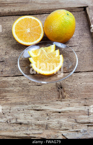 Orange sliced in half and thinly sliced on old table wood Stock Photo