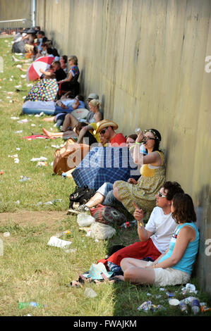 Revelers use any available shade at the Glastonbury Festival 2010, Pilton Somerset UK Stock Photo