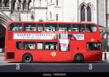 London bus passing the Front facade of the Royal Courts of Justice London, advertising the new movie Batman V Superman Stock Photo