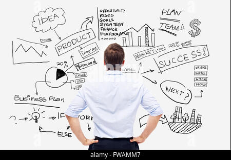 businessman looking at the drawings and writings on white board Stock Photo