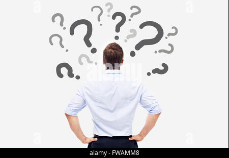 business man looking at the question marks on white board and thinking. Stock Photo