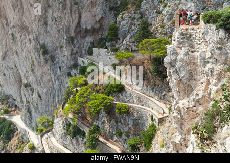 Capri, Italy - August 14, 2015: Tourists looks down on winding mountain road from high viewpoint of Capri island Stock Photo