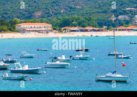 Piana, France - July 5, 2015: Pleasure motor boats and sailing yachts anchored in azure bay near sandy beach Stock Photo