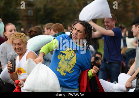 Pillow fight in Kennington Park, London, UK. Hundreds of members of the public brought their own pillows with which to hit each other. Person pillow fighting Stock Photo