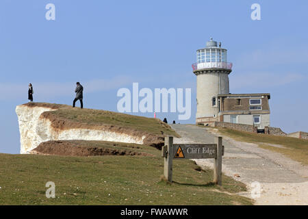 Belle Tout, East Sussex. England, UK. 2nd April 2016. Brave or foolish? A woman stands on the cliff edge near Belle Tout lighthouse to take in the view on a fine day on the Sussex coast as her friend takes a photo. Credit:  Julia Gavin UK/Alamy Live News Stock Photo