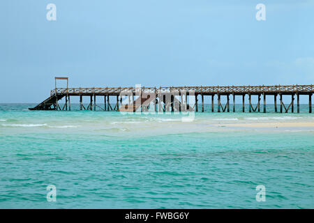 Wooden pier on a tropical beach with clear turquoise water, Zanzibar island Stock Photo