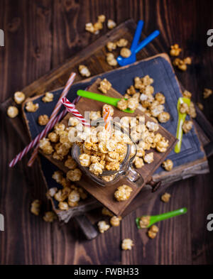 Sweet popcorn with bright colored straws and spoons shot  from above Stock Photo