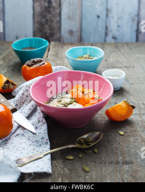 Breakfast bowl with yogurt, persimmon and superfoods Stock Photo