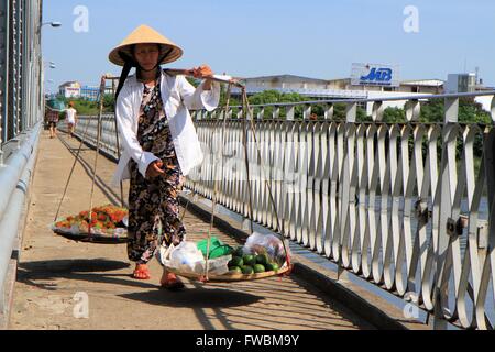 Vietnamese lady carrying baskets os fruits and vegetables, Hue, Vietnam, Asia Stock Photo