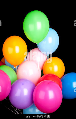 Group of colorful balloons isolated over black wall background Stock Photo