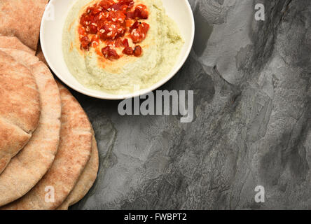 Pita bread and edamame hummus on a slate table with copy space. Stock Photo