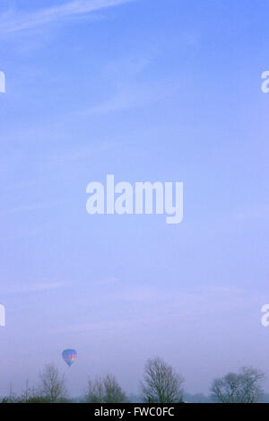 A hot air balloon having just taken off and floating gently over the tree tops. Stock Photo