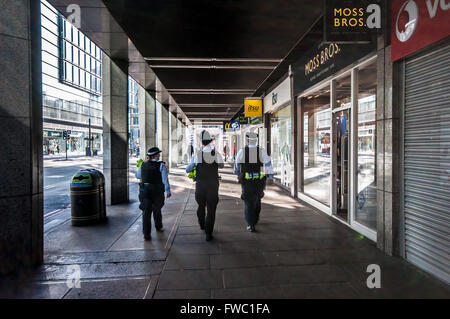 Three policemen on the beat in London, UK. Walking past shop windows. Male. Female Stock Photo