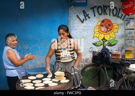 Mayan women baking tortillas in the streets of Antigua, Guatemala, Central America. La Tortolita. Stock Photo