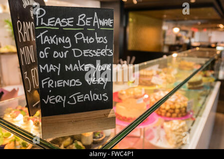 Sign at a restaurant warning customers that photographs of desserts may make your friends very jealous Stock Photo