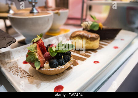 Plate with a selection of three desserts on display in a restaurant. Stock Photo