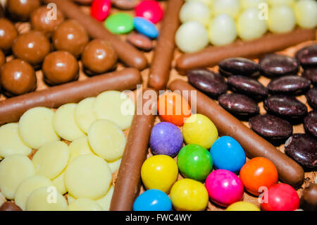 M&Ms, Milky Way Buttons, Maltesers, Smarties Minstrels and Chocolate Fingers decorating the top of a birthday cake. Stock Photo