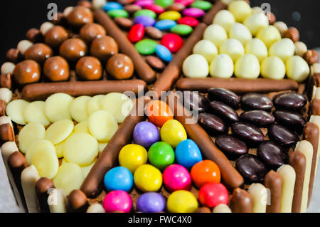 M&Ms, Milky Way Buttons, Maltesers, Smarties Minstrels and Chocolate Fingers decorating the top of a birthday cake. Stock Photo