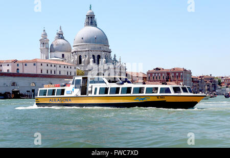 Alilaguna public transport boat and Santa Maria della Salute Catholic church, Venice, Italy. Stock Photo