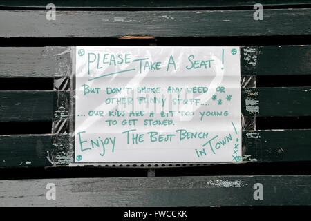 Amusing hand written note on a bench asking people not to sit on the seat and smoke weedin Amsterdam, Netherlands.