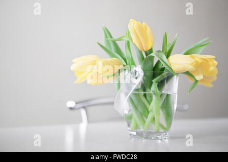 Fresh yellow tulips bouquet over wooden table. Isolated on white background Stock Photo