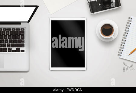 White tablet with isolated screen for mockup on office desk. Laptop, camera, cup of coffee, paper, notepad, pencil on white tabl Stock Photo