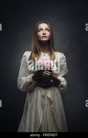 Woman with victorian bride dress and innocent eyes to the sky Stock Photo
