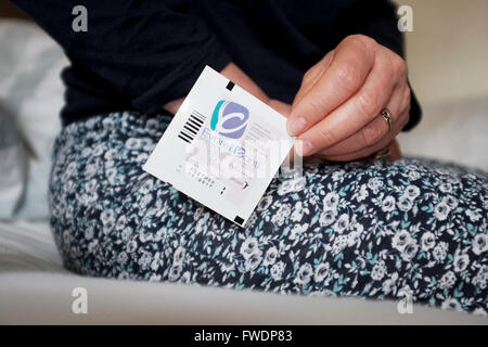 Middle aged woman using Evorel Conti HRT patches to help with the menopause Hormone Replacement Therapy treatment Stock Photo