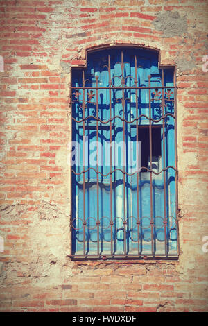 Damaged old window. Grunge red brick wall background. Stock Photo