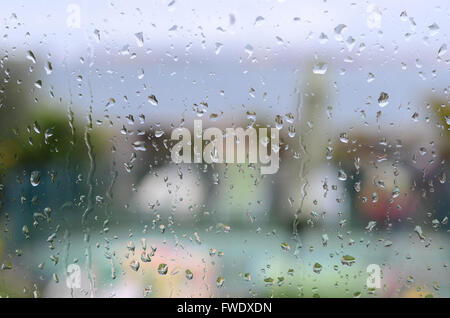 raindrops on window with garden and sea in background Stock Photo