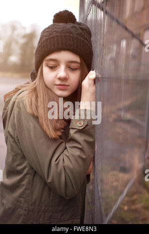Pretty teenage girl wearing a pom pom hat in an urban setting Stock Photo