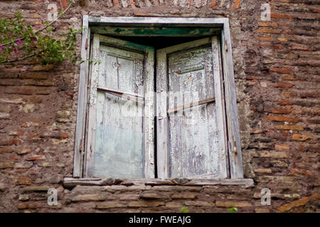 Closed old window with broken shutters Stock Photo