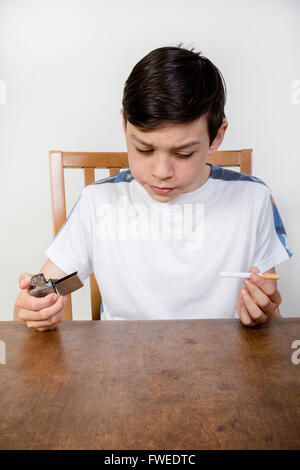 Young boy thinking about smoking a cigarette holding a lighter Stock ...