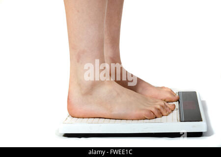 A woman standing on a weight scale Stock Photo - Alamy