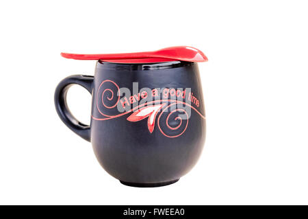 Black and red tea mug with teaspoon on top isolated on white. Stock Photo